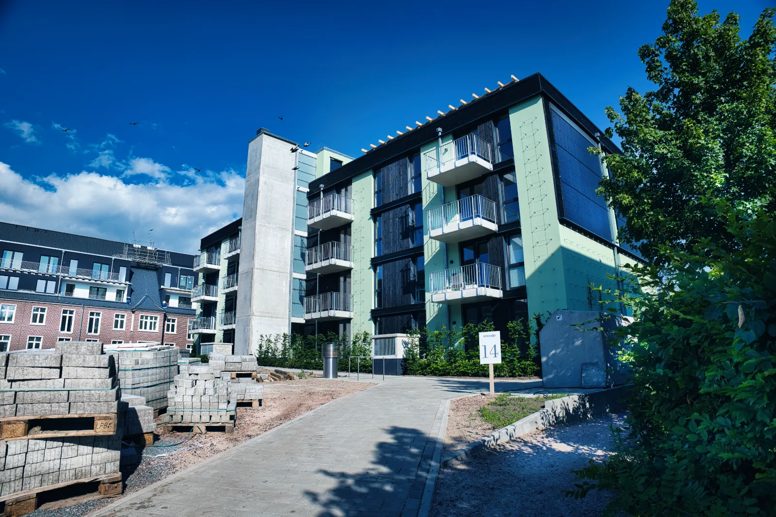 New apartment block beside the railway line with wooded hills behind